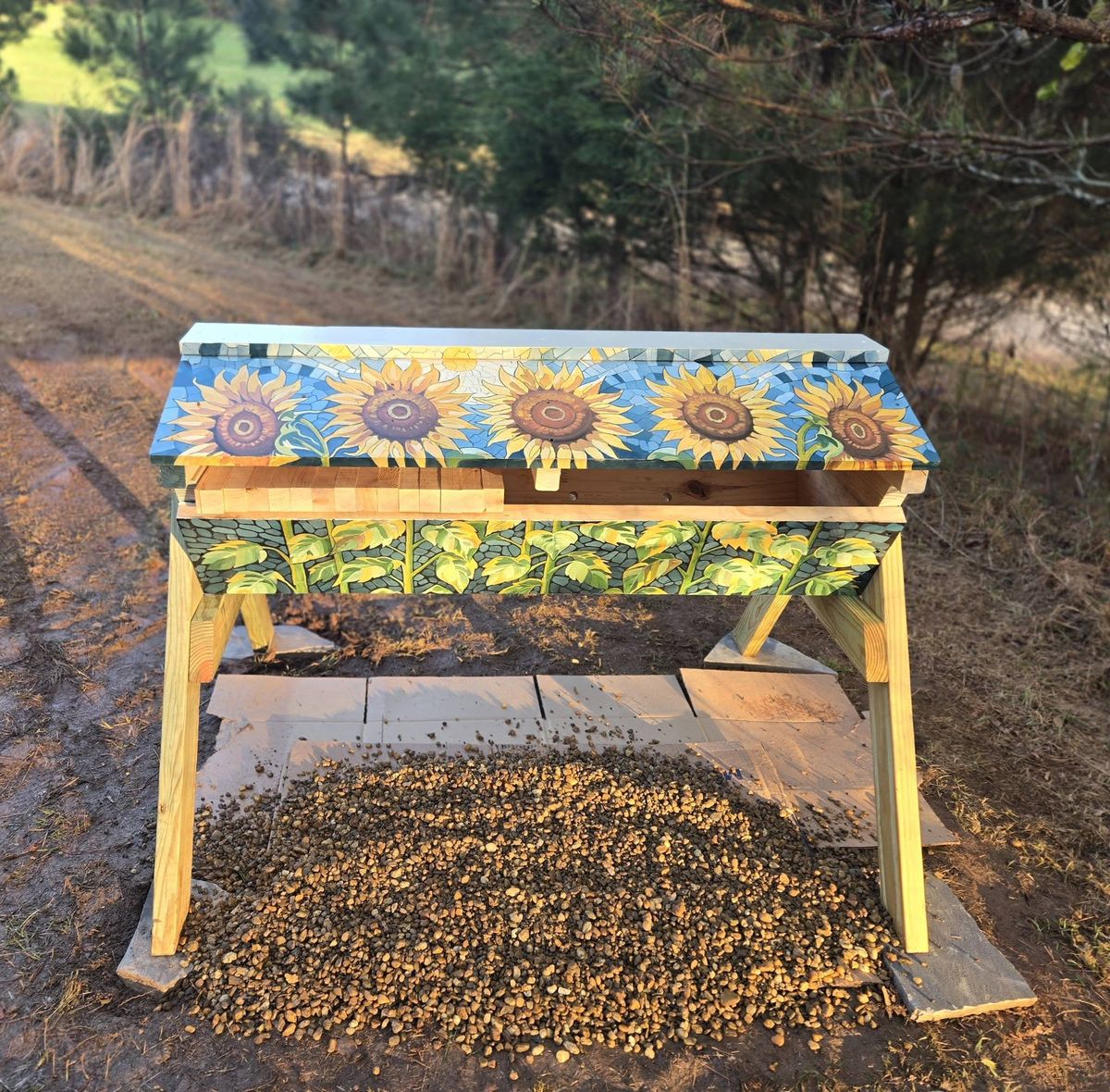A top bar hive painted with sunflowers